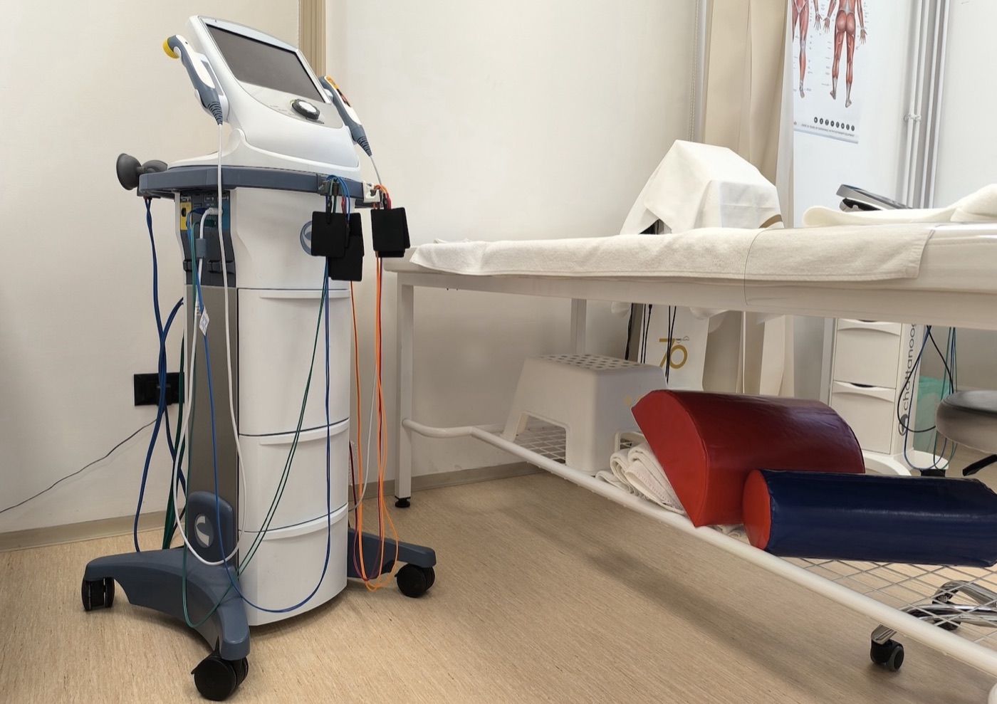Aparat za elektroterapiju sa elektrodama pored terapijskog stola